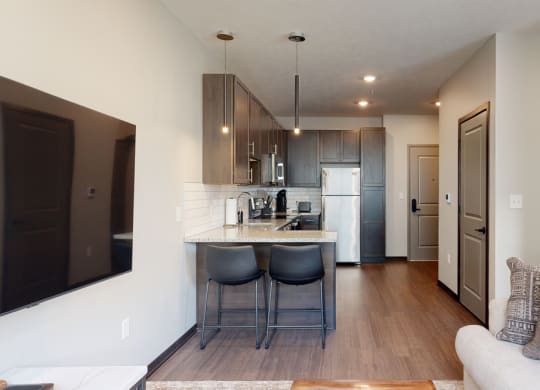a kitchen a with two bar stools at the counter