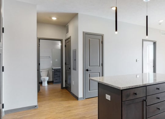 View of kitchen island and hallway leading to the bathroom in the Bliss floor plan at Haven at Uptown in Lincoln, NE