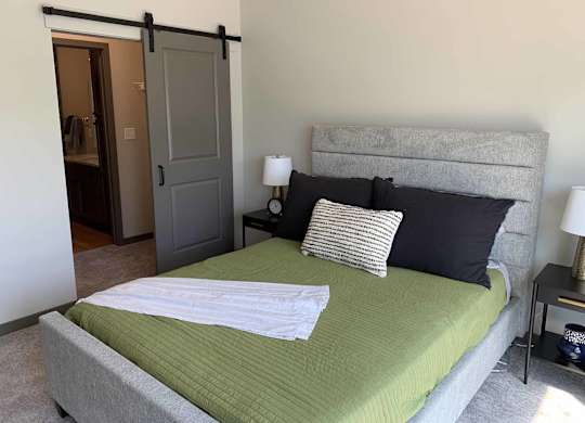 a bedroom with a bed and a closet with sliding barn door