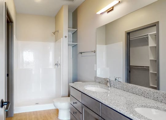 View of dual sink counter tops and shower in bathroom attached to the master bedroom at Haven at Uptown in Lincoln, NE