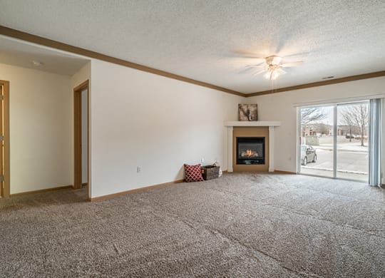 Bright living room with fire place and ceiling fan at The Northbrook Apartment Homes, Lincoln, NE