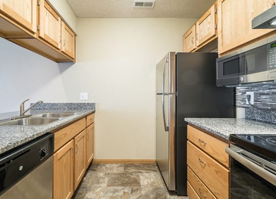 Galley style kitchen with stainless steel GE appliances at Skyline View Apartments in Lincoln NE