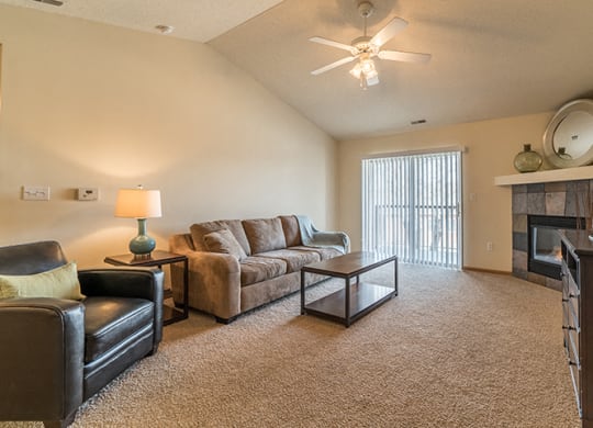 Living room with ceiling fan and lots of natural light at Pinebrook Apartments in Lincoln NE