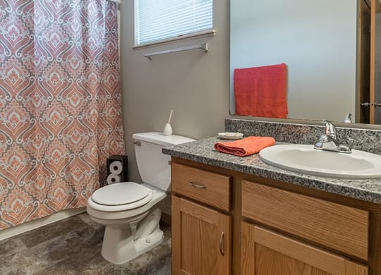 Tiled bathroom with bathtub and granite countertop at Skyline View Apartments in Lincoln NE