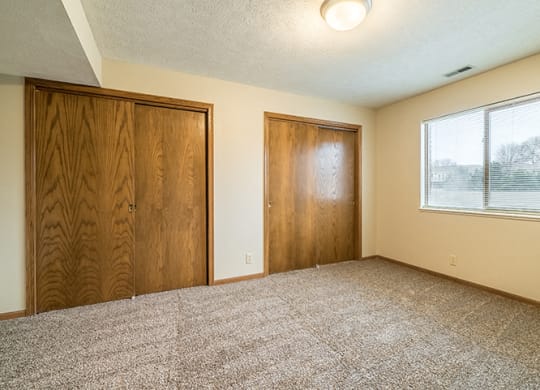 Bedroom with two closets providing plenty of storage space at Fountain Glen Apartments