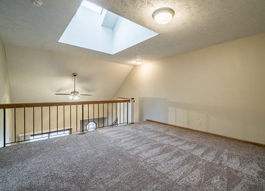 View of the loft with a skylight in a Fountain Glen Apartment