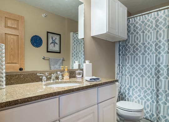 a large bathroom with plenty of cabinet space and a bathtub at Grand Legacy Apartments