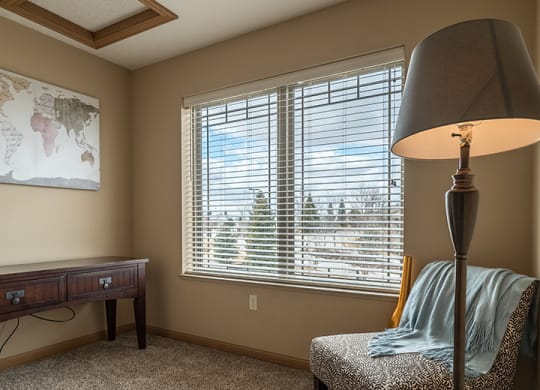 a den space with a reading chair and a desk