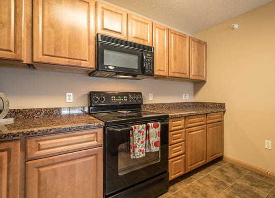 a kitchen with black appliances and wooden cabinets