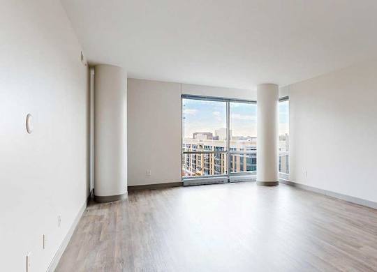 a spacious bright living area with large windows and wood-style flooring