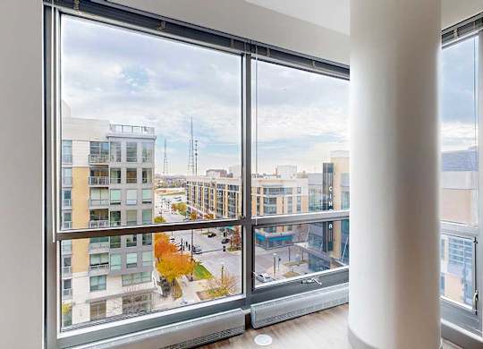 a floor to ceiling window with a view of midtown crossing from the living room of the 2-bedroom Tuscon