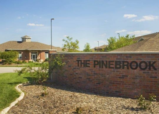 Exteriors-Pinebrook Apartments Sign and Clubhouse View in Lincoln NE
