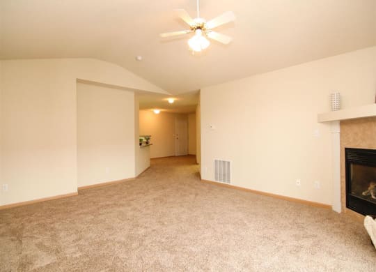 Living room with fire place and ceiling fan at Northbrook Apartments in Lincoln NE