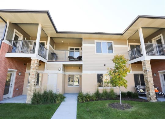 building exterior with tan siding and stone columns