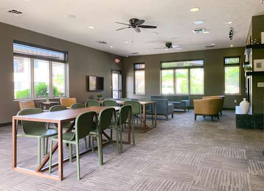 a conference room with tables and chairs and a ceiling fan