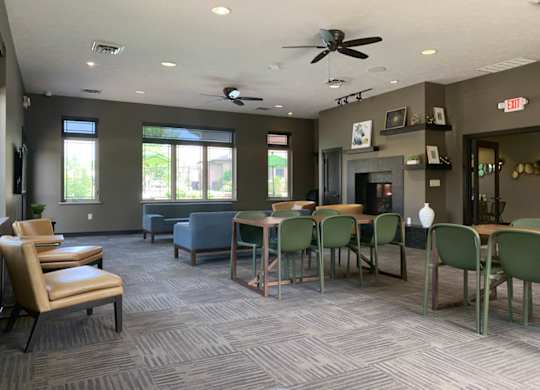 a great room with tables and chairs and a fireplace