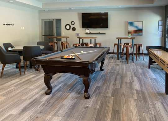 a games room with a pool table and a tv