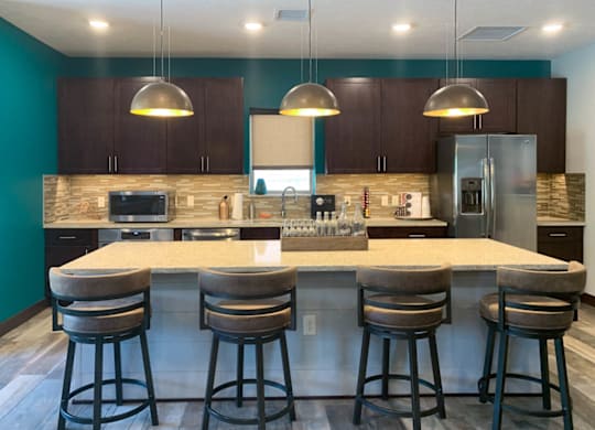 a kitchen with a large island with four bar stools