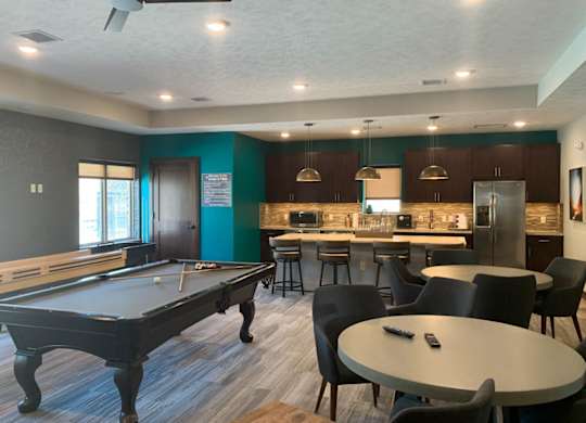 a game room with a pool table and a bar