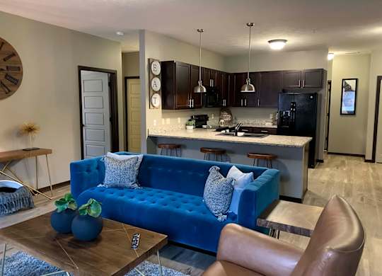 a blue couch in a living room next to a kitchen