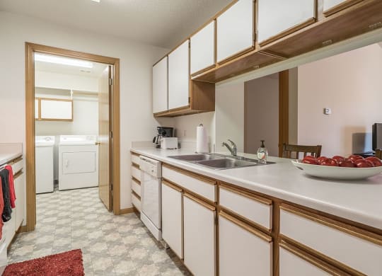 a kitchen with white cabinets and a sink      and a door