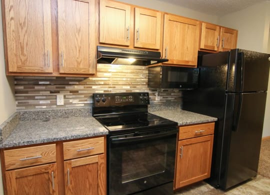 a kitchen with black appliances and granite counter tops