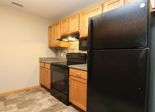 a kitchen with black appliances and wooden cabinets