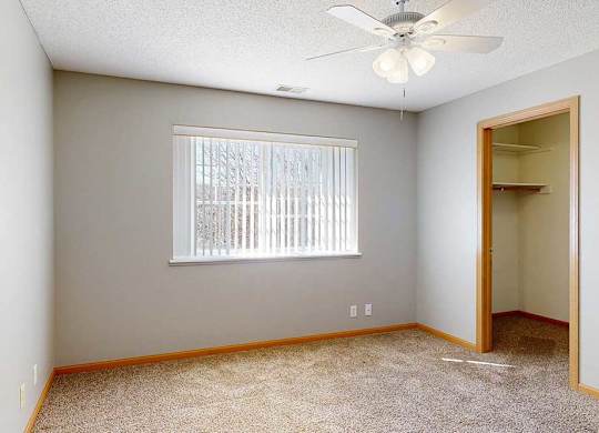bedroom with a ceiling fan and a window with blinds
