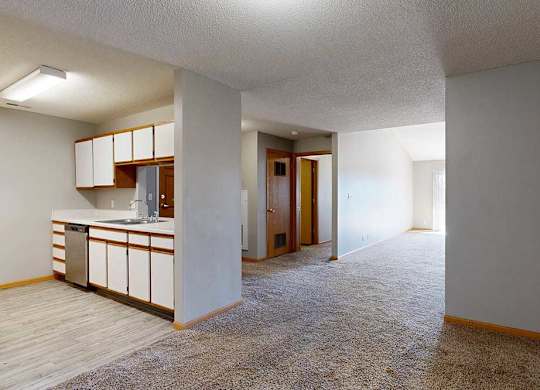 kitchen with white cabinets and hallway to living room