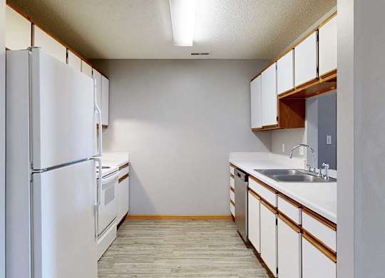 galley-style kitchen with a white appliances and white cabinets.