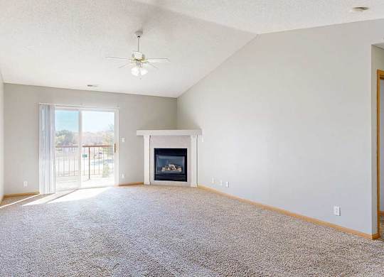 living room with a fireplace, ceiling fan, and patio doors