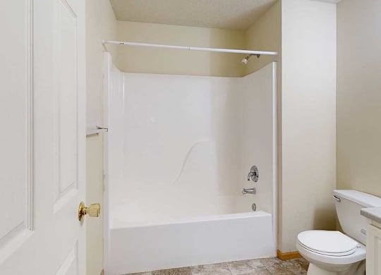 A white bathroom with a toilet and a bathtub.