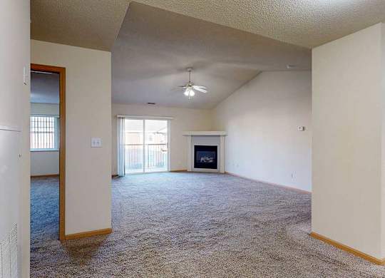 spacious living room with a fireplace and a ceiling fan