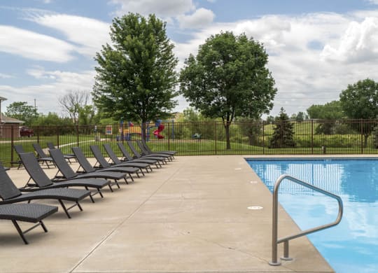 Large outdoor pool with lounge chairs at The Northbrook Apartments