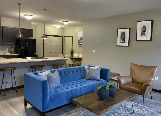 a blue couch in a living room next to a kitchen
