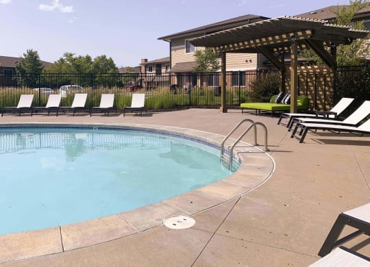 a resort style pool with lounge chairs and a gazebo