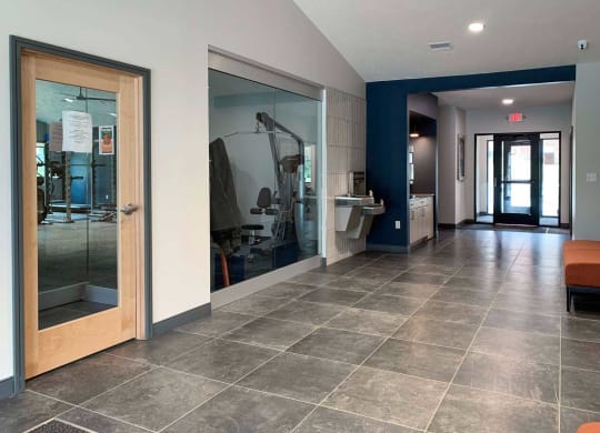 a view of a hallway with glass doors in an apartment clubhouse