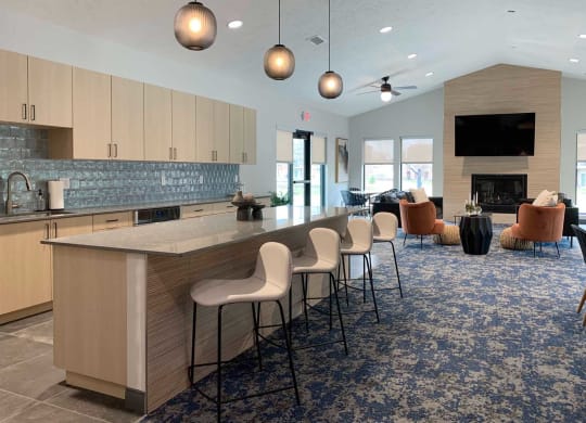 a large kitchen with a bar and a clubhouse community room with a fireplace