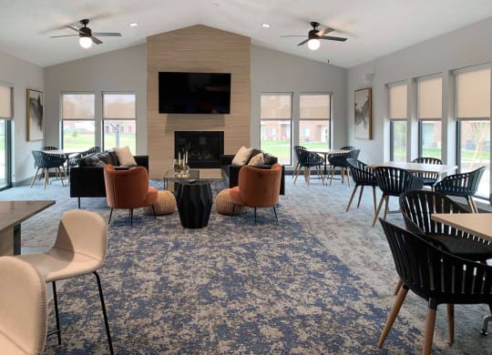 a large living room with chairs and tables and a fireplace