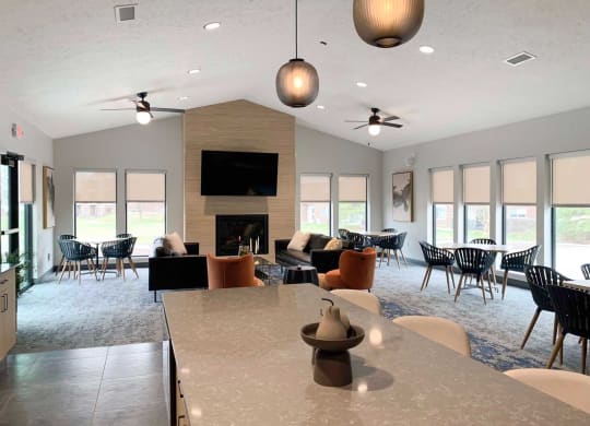a large clubhouse with a table and chairs and a fireplace