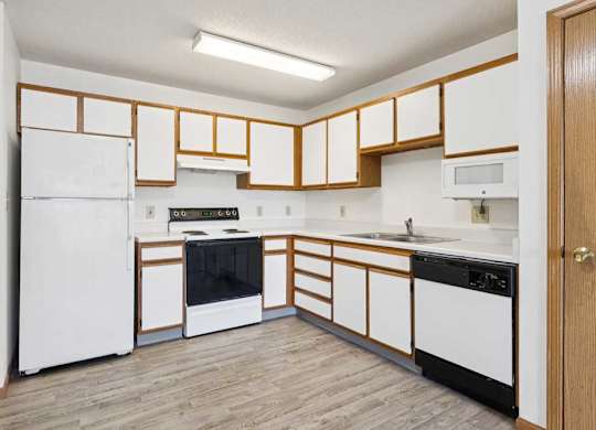 A kitchen with white appliances and wooden cabinets.