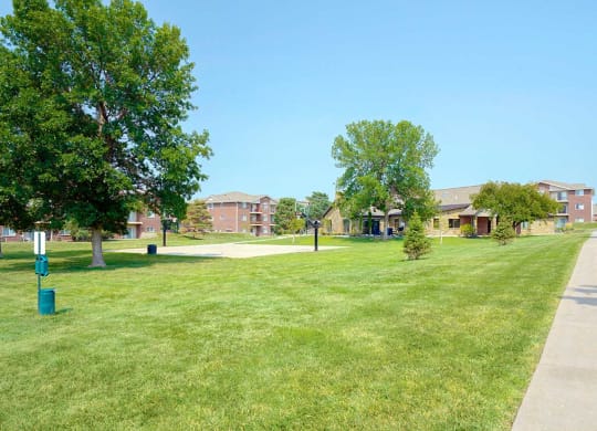 Expansive green lawn with walking paths and apartments in the background
