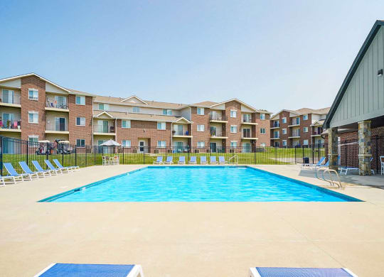 Poolside view with an apartment building in the background