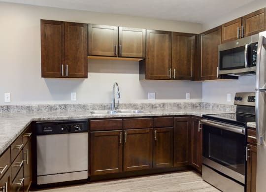 Renovated kitchen with granite counters and new appliances at Northridge Heights Apartments