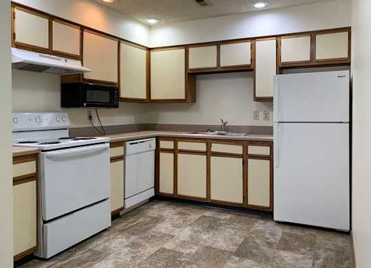 a kitchen with white appliances and white and wooden cabinets