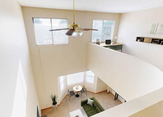 View of a living room looking down from a lofted bedroom