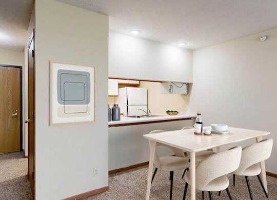 A dining room with a table and chairs.