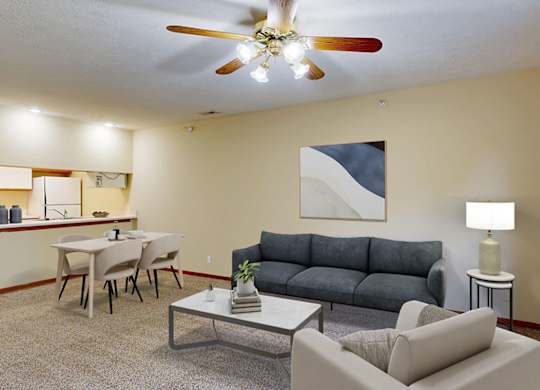 A living room with a navy couch, a coffee table, and a ceiling fan.