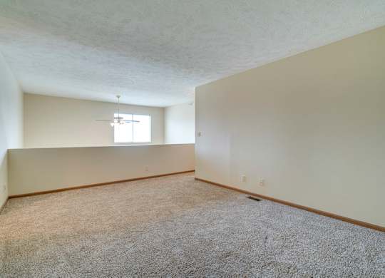 A room with a carpeted floor and a window.