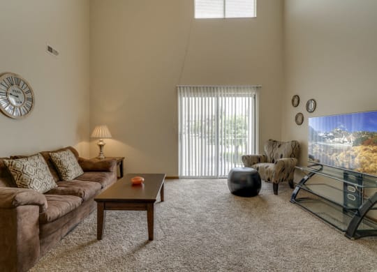 Large windows and sliding doors provide lots of natural lighting in the living space at Pine Lake Heights Apartments